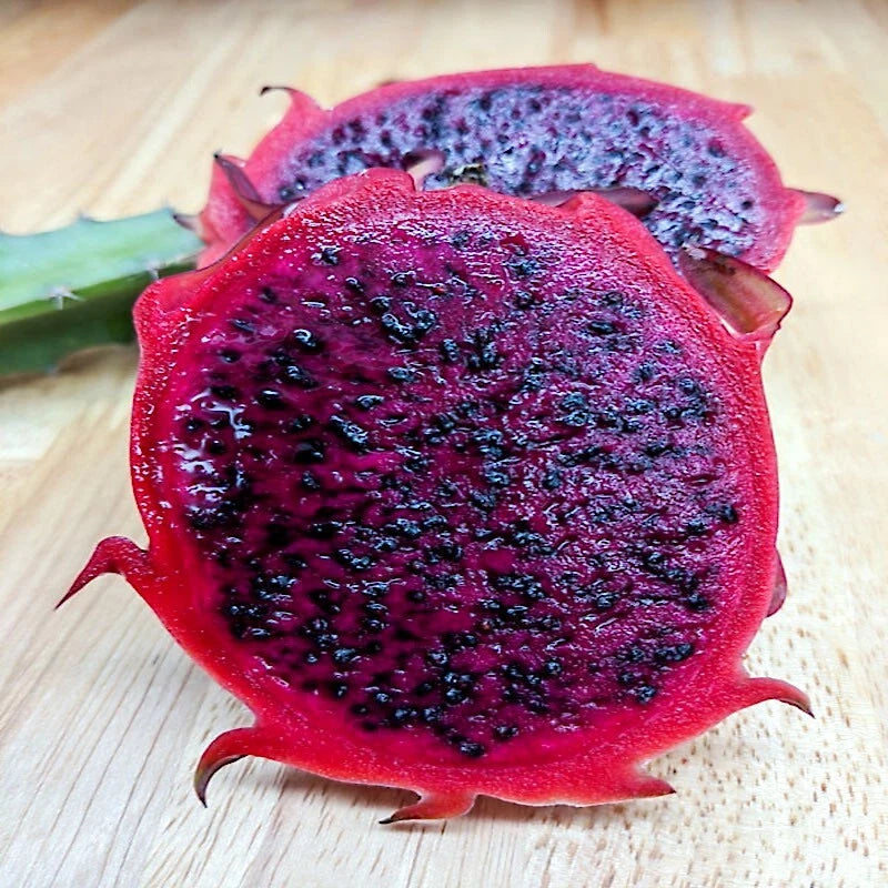 Sliced red dragon fruit on a wooden surface